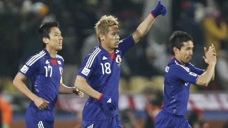 Japan's midfielder Keisuke Honda (C) celebrates after scoring the opening goal during the Group E first round 2010 World Cup football match Denmark vs. Japan on June 24, 2010 at Royal Bafokeng stadium in Rustenburg. NO PUSH TO MOBILE / MOBILE USE SOLELY WITHIN EDITORIAL ARTICLE   --     AFP PHOTO / THOMAS COEX (Photo credit should read THOMAS COEX/AFP via Getty Images)
